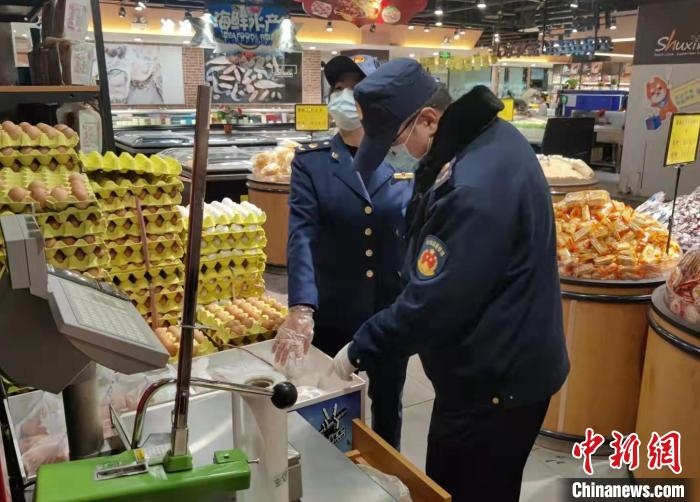 圖為疫情期間，甘肅嘉峪關(guān)市場(chǎng)監(jiān)管局工作人員檢查蔬菜市場(chǎng)?！?柴佳楠 　攝