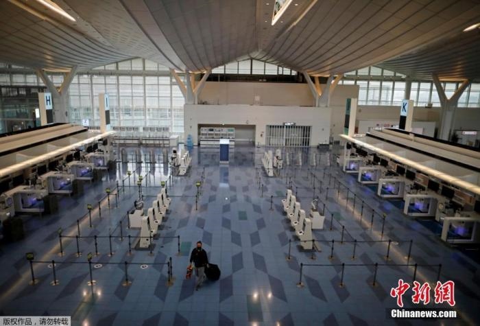 資料圖：日本東京，東京國際機(jī)場，一名乘客在國際航班航站樓的登機(jī)區(qū)。