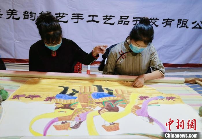 圖為皮繡藝人在市集上“秀”指尖技藝?！●R銘言 攝