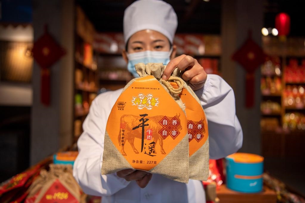 1月27日，在平遙古城南大街的一家平遙牛肉店內(nèi)，工作人員展示一款牛肉產(chǎn)品。新華社記者 楊晨光 攝