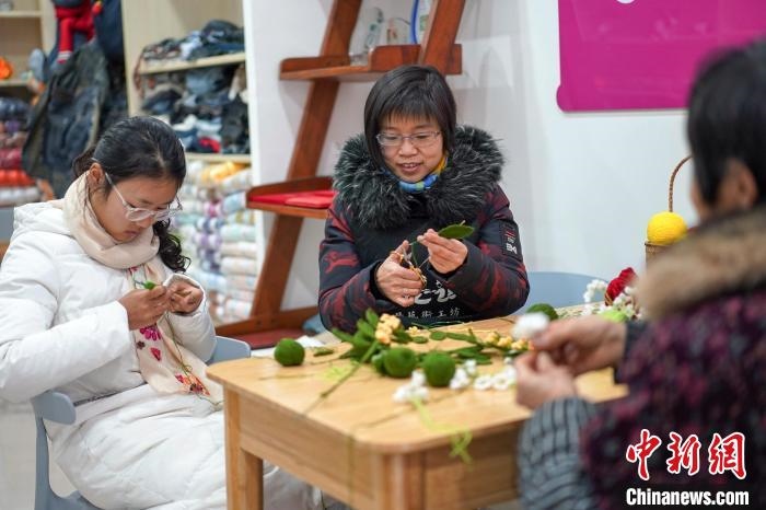 文創(chuàng)工作室的姐妹們正在鉤織月桂葉片。　古良駒 攝