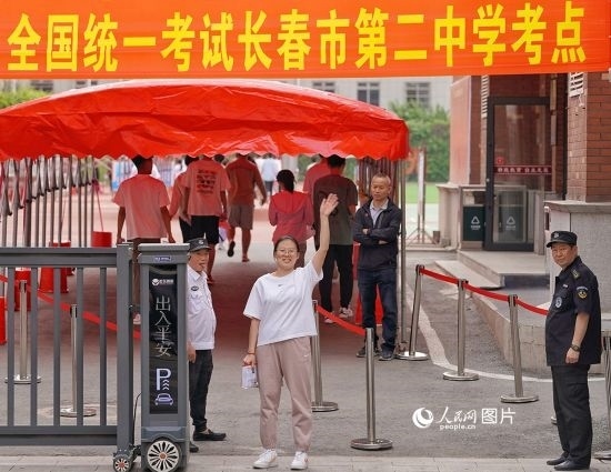 6月7日，在長春市第二中學(xué)考點，一名考生信心滿滿進(jìn)入考場，并與家長揮手致意。人民網(wǎng)記者 李洋攝