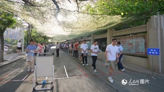 6月7日，烏魯木齊市第七十中學(xué)門口，考生們有序進(jìn)入考場。人民網(wǎng) 李欣洋攝