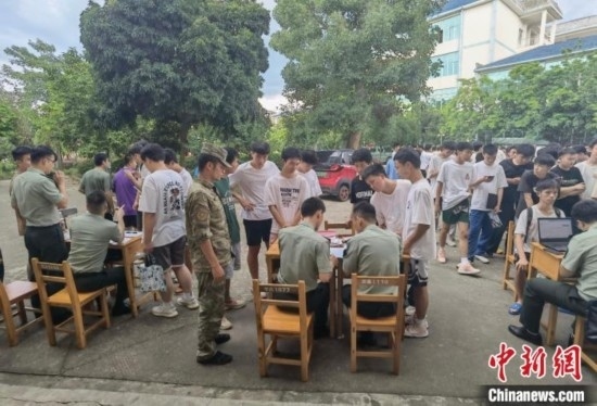 專武干部在發(fā)放兵役登記證。韋碩 攝