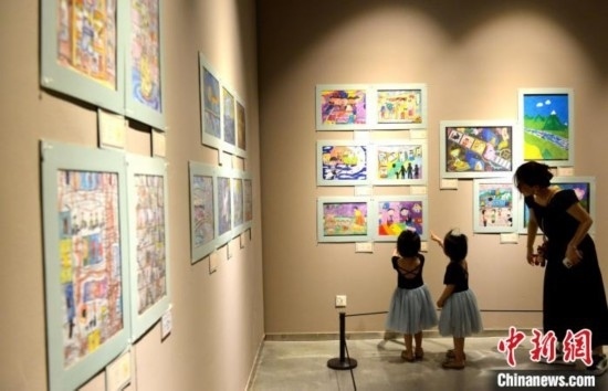 圖為家長(zhǎng)帶著孩子參觀展覽。呂明 攝