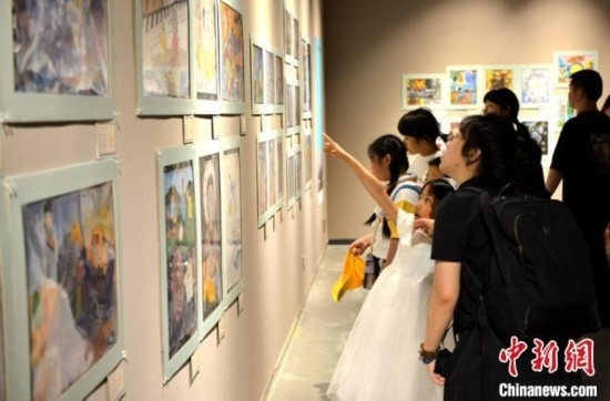 圖為家長(zhǎng)帶著孩子參觀展覽。呂明 攝