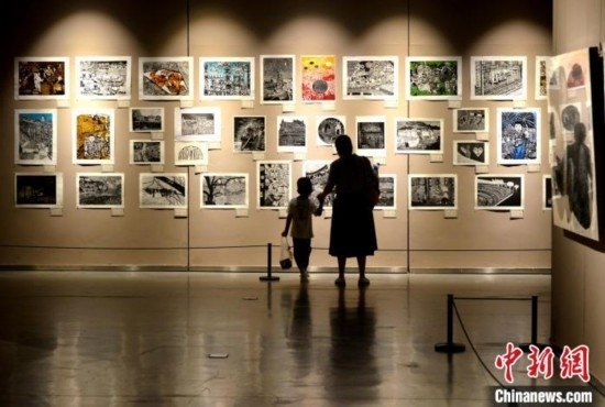 圖為家長(zhǎng)帶著孩子參觀展覽。呂明 攝