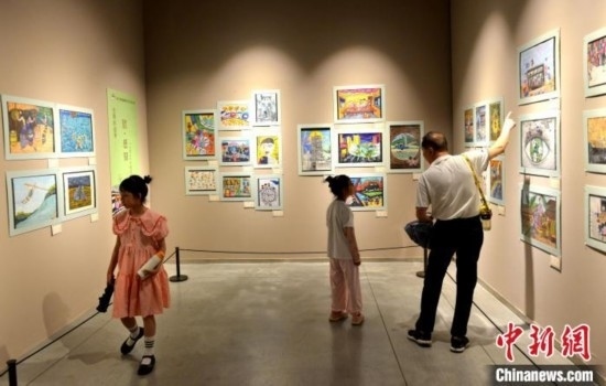 圖為家長(zhǎng)帶著孩子參觀展覽。呂明 攝