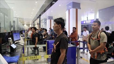 6月13日，乘坐中老鐵路國(guó)際旅客列車(chē)的旅客在磨憨邊檢大廳排隊(duì)候檢。李揚(yáng) 攝