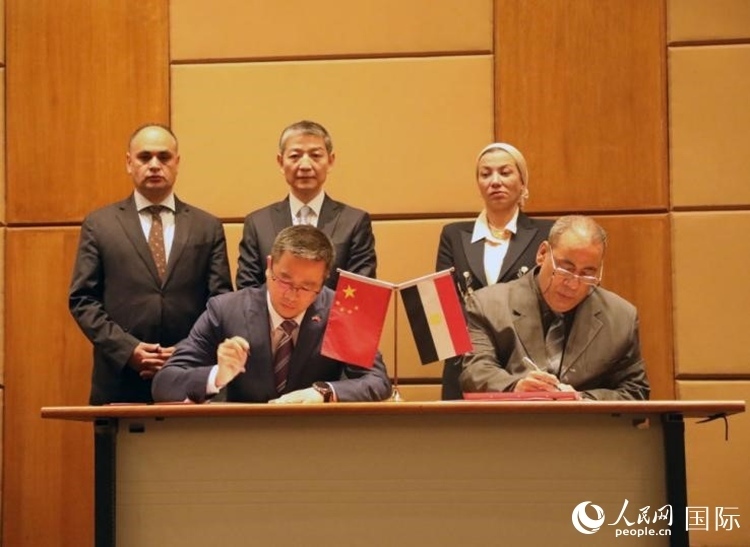 中國(guó)駐埃及使館公使張朝陽(yáng)與埃環(huán)境事務(wù)署工程和項(xiàng)目管理局局長(zhǎng)阿卜杜勒阿齊茲簽署交接證書。沈小曉攝