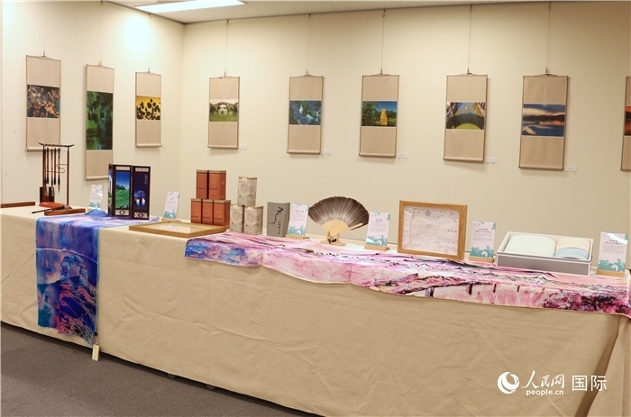 現(xiàn)場展出的馮學敏攝影作品與湖州市特色工藝品。（人民網(wǎng) 許可攝）