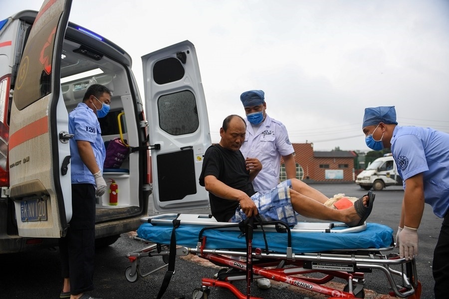 8月1日，在北京市門頭溝區(qū)妙峰山鎮(zhèn)妙峰山民族學(xué)校臨時(shí)安置點(diǎn)，北京急救中心工作人員在轉(zhuǎn)運(yùn)一名受傷村民。新華社記者 鞠煥宗 攝