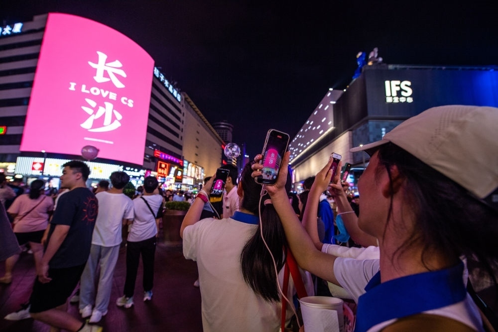  游客在長(zhǎng)沙市天心區(qū)黃興路步行街打卡、拍照（6月7日攝）。新華社記者 陳思汗 攝