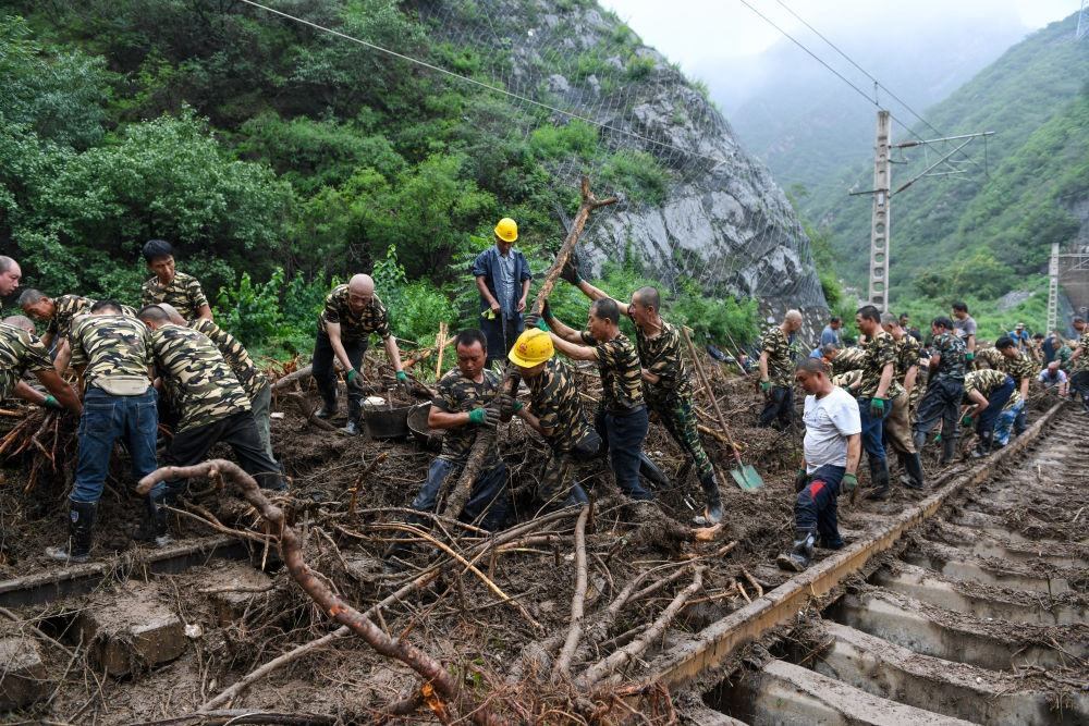 8月1日，在北京市門頭溝區(qū)水峪嘴村附近一段被阻斷的鐵路線上，中鐵六局工作人員在清理軌道上的雜物，全力恢復交通。新華社記者 鞠煥宗 攝