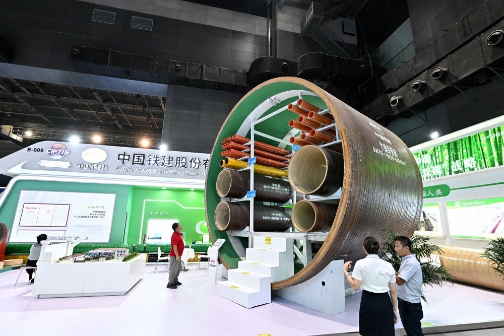 9月2日，在國家體育館舉行的服貿(mào)會環(huán)境服務(wù)專題展上，客商在中國鐵建展位竹纏繞管廊旁了解信息。新華社記者 李鑫 攝