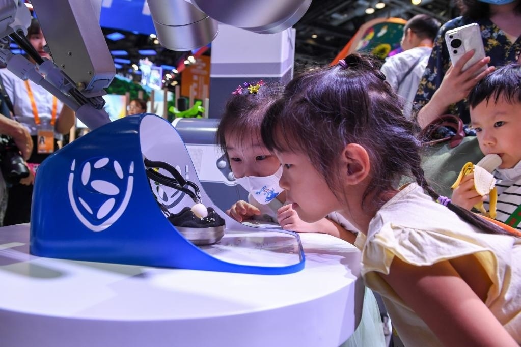 9月3日，幾名小朋友在國家會(huì)議中心觀看單孔腔鏡手術(shù)機(jī)器人展示。新華社記者 鞠煥宗 攝