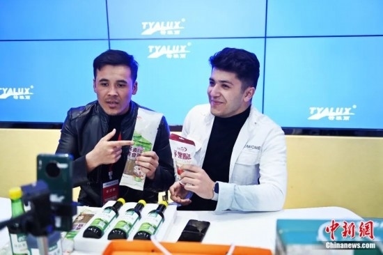 2023年3月，甘肅省慶陽(yáng)市環(huán)縣電商創(chuàng)業(yè)孵化基地內(nèi)，來(lái)自蘭州文理學(xué)院的塔吉克斯坦留學(xué)生正在協(xié)助主播直播帶貨當(dāng)?shù)剞r(nóng)特產(chǎn)品。李亞龍 攝