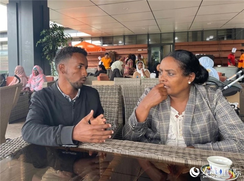 約漢斯（圖左）與德貝拉在友誼廣場(chǎng)咖啡廳交談。人民網(wǎng)記者 趙艷紅攝