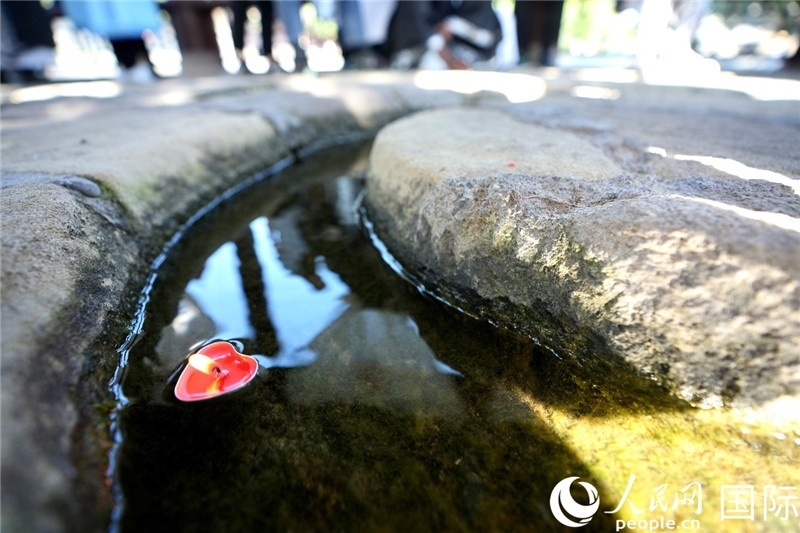 圖為水渠里流過的“桃心”蠟燭。人民網(wǎng) 盧鵬宇攝