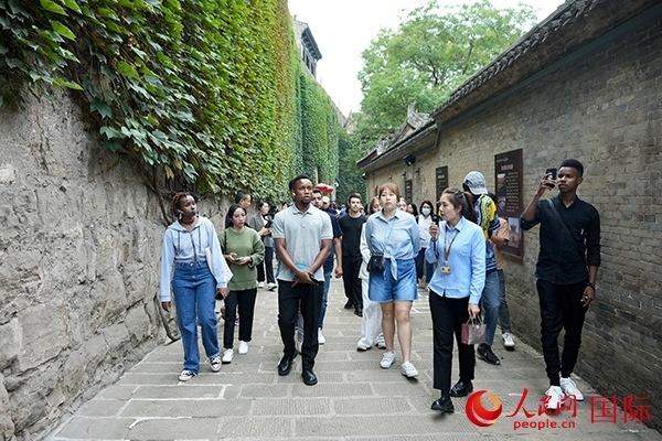 選手們認(rèn)真聆聽導(dǎo)游講解。人民網(wǎng) 盧鵬宇攝