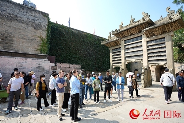 選手們認(rèn)真聆聽導(dǎo)游講解。人民網(wǎng) 盧鵬宇攝