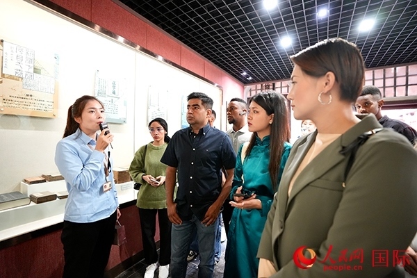 選手們認(rèn)真聆聽導(dǎo)游講解。人民網(wǎng) 盧鵬宇攝