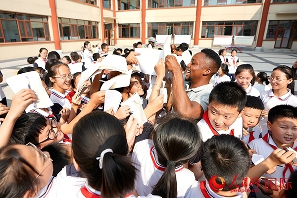 孩子們和選手互動(dòng)簽名。人民網(wǎng) 盧鵬宇攝