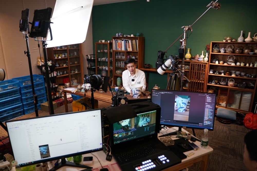 ↑在景德鎮(zhèn)，工作人員通過(guò)網(wǎng)絡(luò)直播推介陶瓷產(chǎn)品（2023年2月22日攝）。