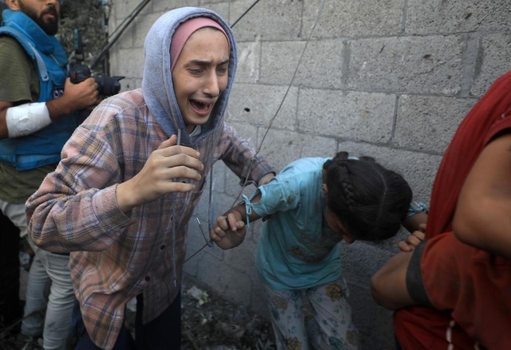 11月6日，人們從加沙地帶中部地區(qū)一處被炸難民營逃離。新華社發(fā)（亞西爾·庫迪攝）