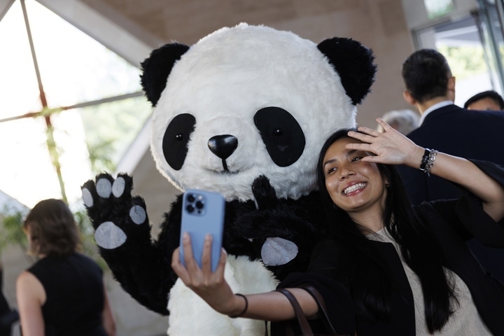 2022年8月24日，在美國華盛頓中國駐美國大使館，來賓與大熊貓玩偶合影。