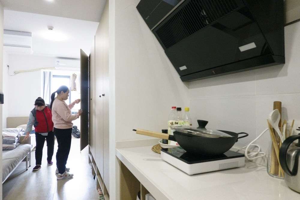 住戶在閔行區(qū)新時代城市建設(shè)者管理者之家收拾房間。