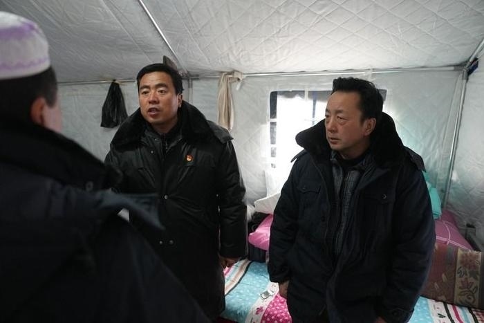 2023年12月22日，積石山縣大河家鎮(zhèn)大河村黨支部書記馬成忠（右二）在帳篷里和受災群眾交流。新華社記者 陳斌 攝