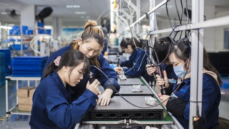 在新亞勝光電的產(chǎn)品線上，工人正進行產(chǎn)品組建和安裝布線。受訪者供圖