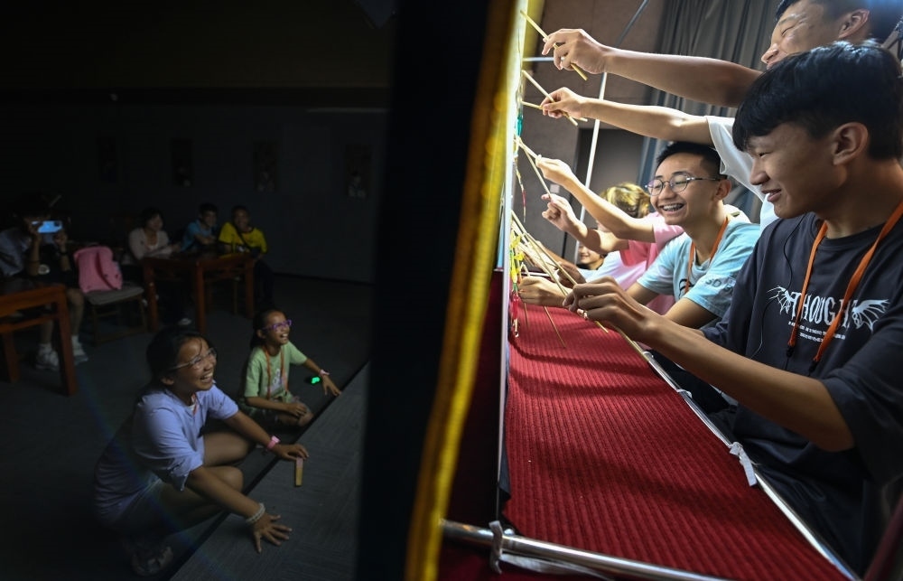 2023年8月8日，進行暑期研學的學生在位于陜西省西安市的中國秦腔藝術博物館體驗皮影戲演出。新華社記者 鄒競一 攝