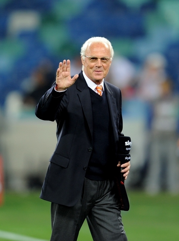 這是2010年7月7日，在南非德班舉行的2010年足球世界杯德國隊對陣西班牙隊的半決賽前，貝肯鮑爾接受電視臺采訪時和友人打招呼。新華社記者 王毓國 攝