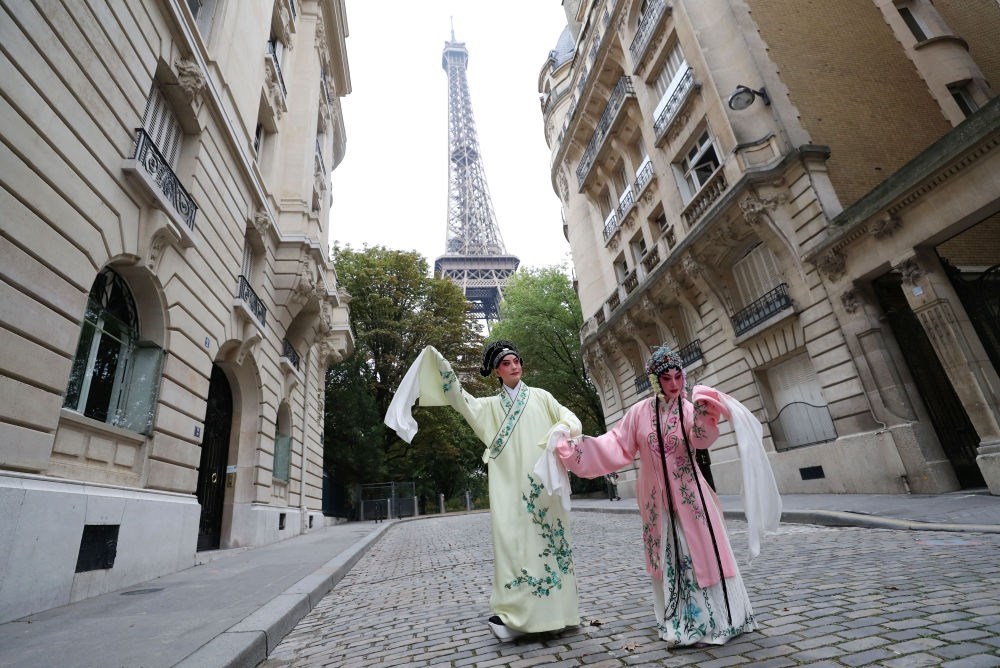 2023年9月13日，江蘇省演藝集團(tuán)昆劇院院長施夏明（左）和江蘇省演藝集團(tuán)昆劇院國家一級演員孔愛萍在法國巴黎埃菲爾鐵塔附近參加昆曲快閃。新華社記者 高靜 攝