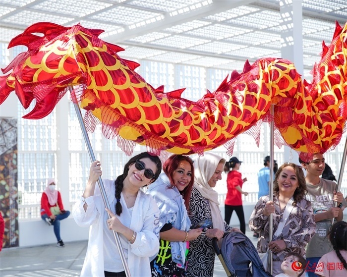 游客體驗(yàn)舞龍。 人民網(wǎng) 塔里克·易卜拉欣攝