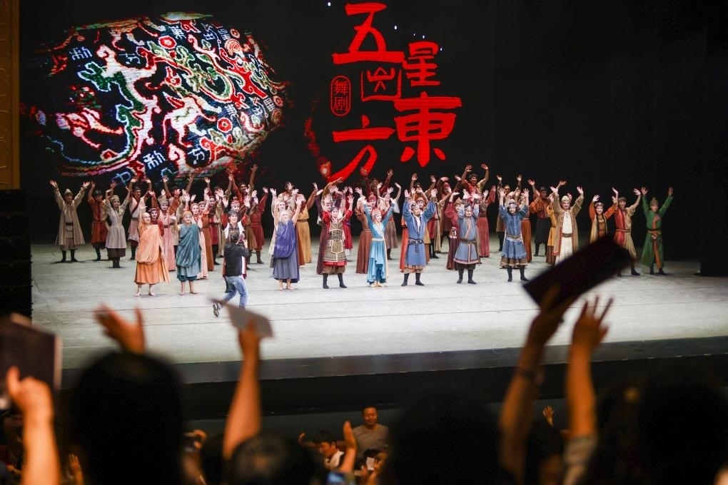 2023年7月31日，新疆和田地區(qū)新玉歌舞團在烏魯木齊京劇院演出舞劇《五星出東方》后和觀眾互相揮手致意。這場演出是第六屆中國新疆國際民族舞蹈節(jié)的參演劇目之一，曾榮獲國家“文華獎”等。新華社記者 郝昭 攝