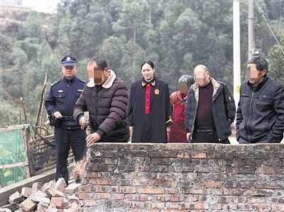  圖③：庭審結束后，在法官的見證下，陳某在院壩邊重新開鑿一條通道。