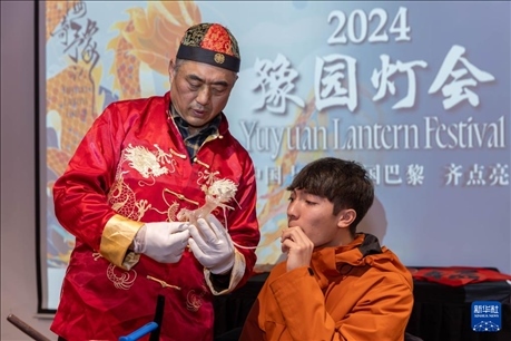 1月28日，在上海豫園舉行的民俗活動上，美國馬斯卡廷中學(xué)學(xué)生在非遺傳承人的指導(dǎo)下吹糖偶。 新華社記者 王翔 攝