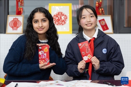 1月28日，美國馬斯卡廷中學(xué)學(xué)生（左）和復(fù)旦大學(xué)第二附屬學(xué)校學(xué)生展示互相送出的寫有寄語祝福的紅包。 新華社記者 王翔 攝