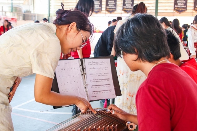 志愿者教師指導(dǎo)學(xué)生彈奏古箏?；顒?dòng)主辦方供圖