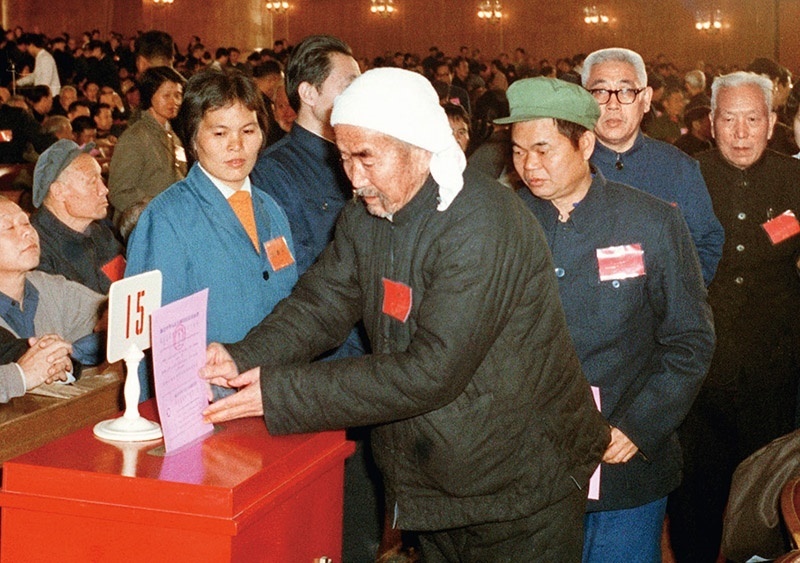 我國現(xiàn)行憲法于1982年12月4日由第五屆全國人大第五次會議通過并公布施行。根據(jù)改革開放和社會主義現(xiàn)代化建設(shè)的實踐和發(fā)展，全國人大于1988年、1993年、1999年、2004年、2018年先后5次作出必要的、也是十分重要的修正。圖為出席第五屆全國人民代表大會第五次會議的代表投票表決《中華人民共和國憲法》（資料照片）。 新華社發(fā)