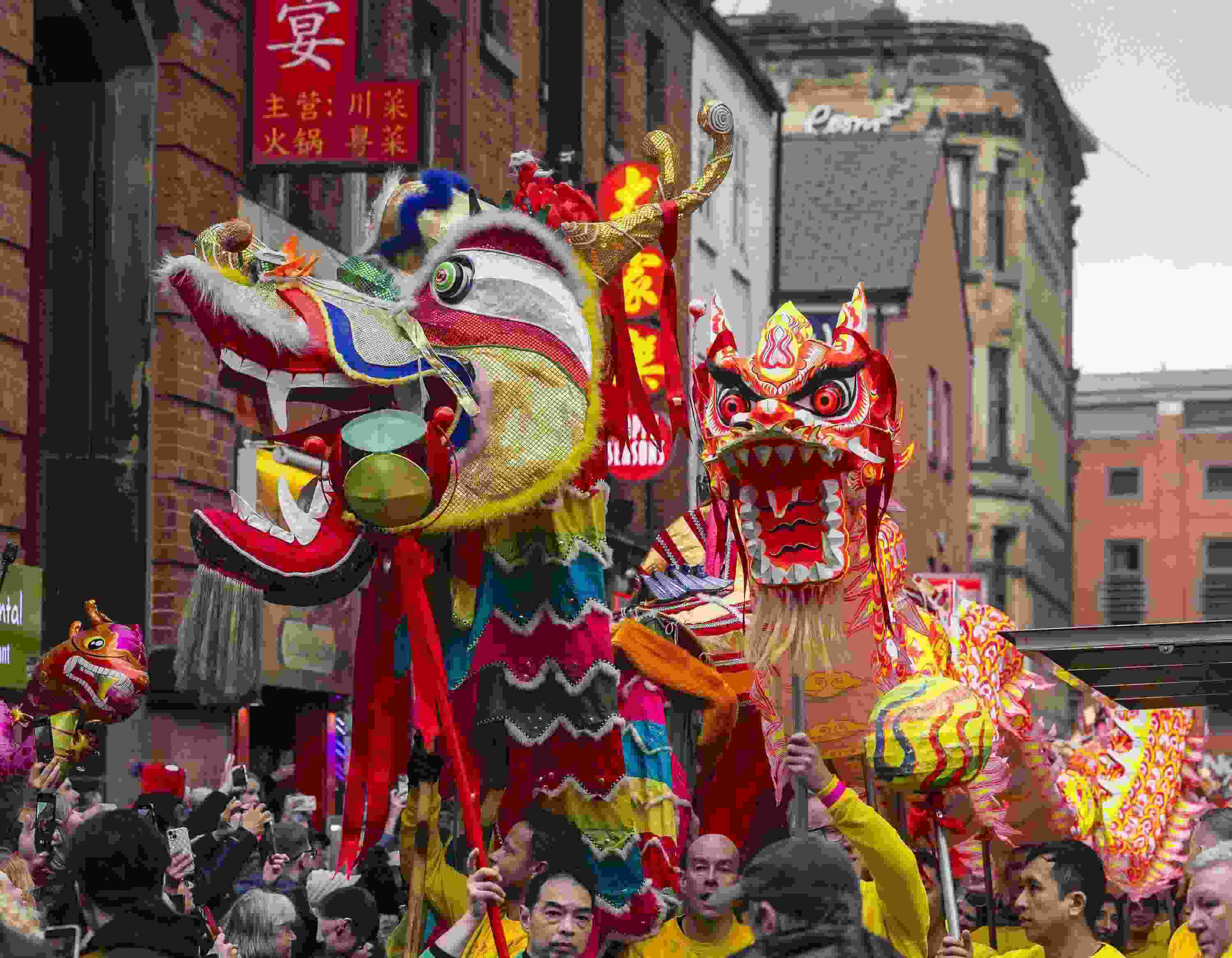 △ 當?shù)貢r間2024年2月11日，英國曼徹斯特，表演者進入中國城，參加中國農(nóng)歷龍年春節(jié)的慶?；顒印? width=