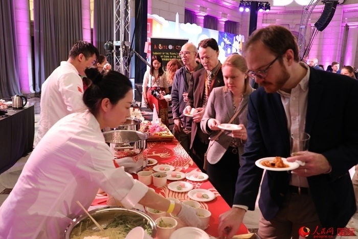 當(dāng)?shù)貢r(shí)間3月7日晚，華盛頓聯(lián)合車站廣場(chǎng)舉行駐美使團(tuán)“使館主廚挑戰(zhàn)賽”。圖為當(dāng)?shù)孛癖娫谥袊?guó)展臺(tái)前體驗(yàn)中國(guó)美食。人民網(wǎng)記者 李志偉攝