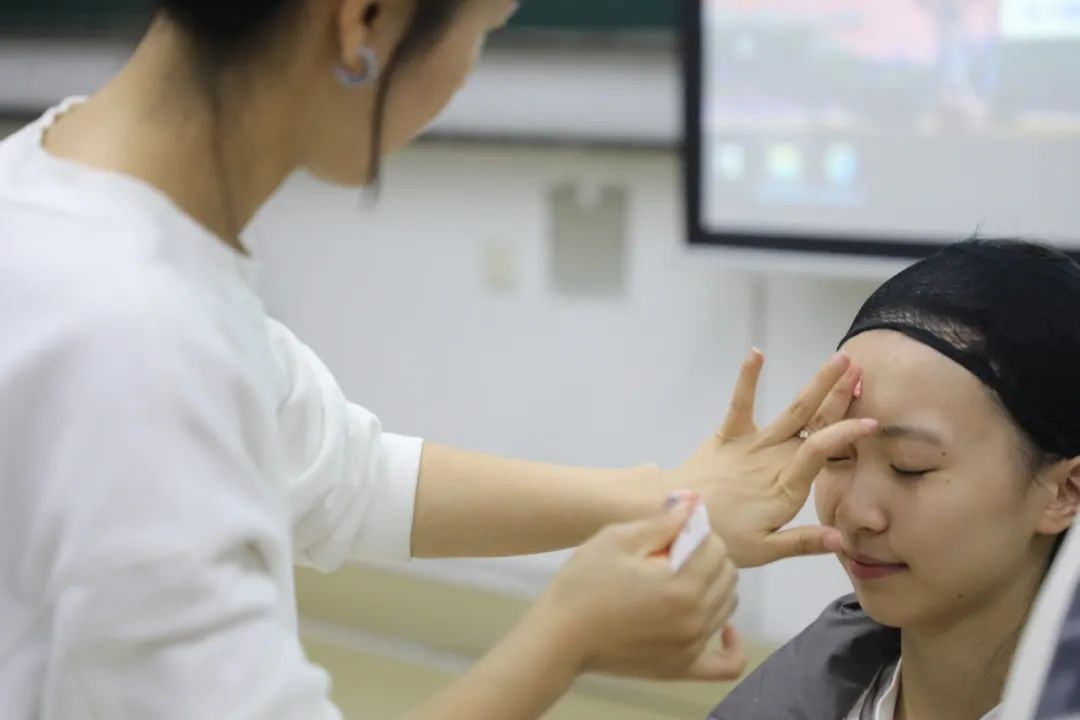 課堂上，一名學(xué)生在體驗(yàn)上戲妝。學(xué)校供圖