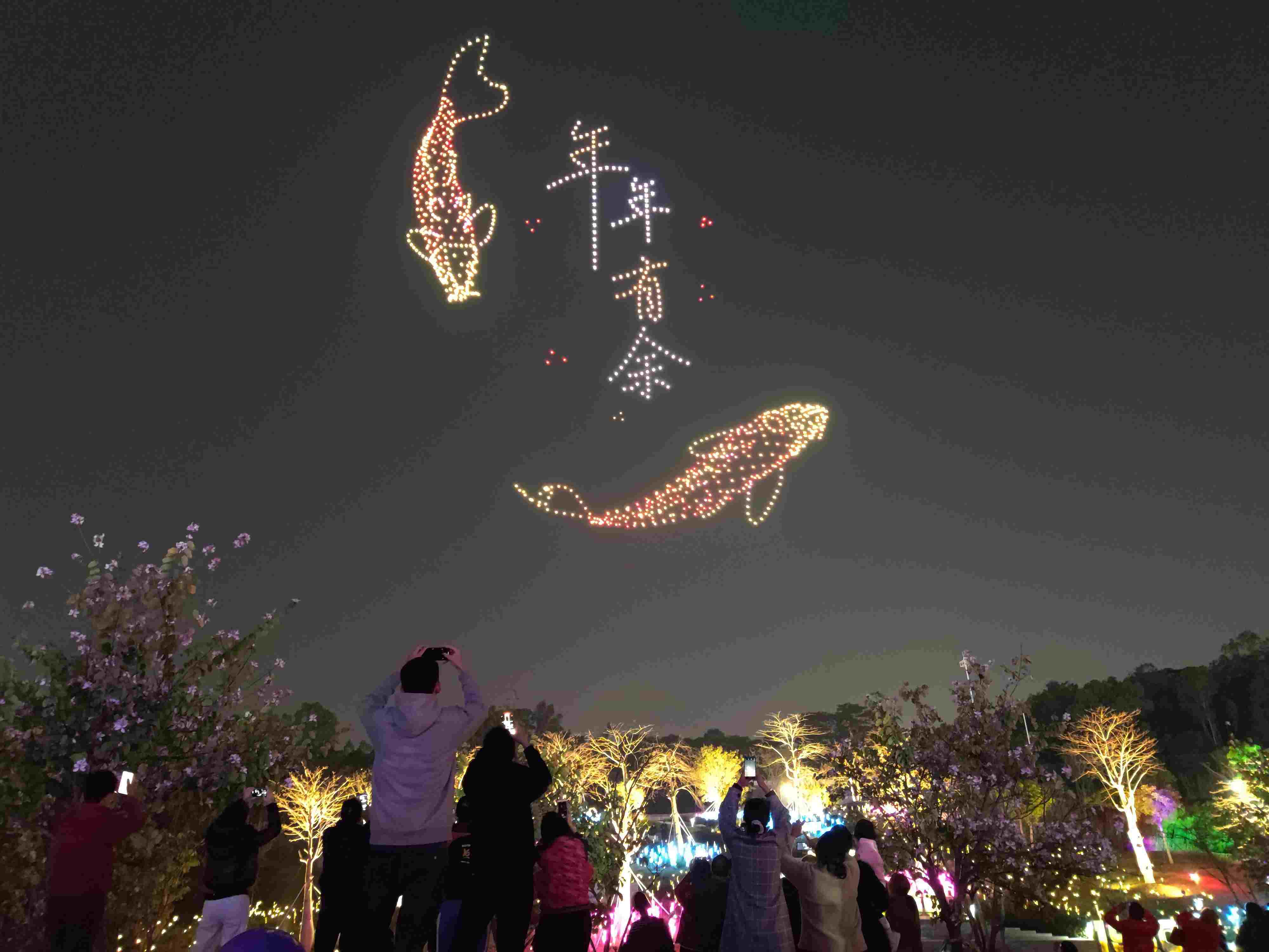 △ 2024年2月10日，深圳北站中心公園，春節(jié)主題無(wú)人機(jī)燈光秀引來(lái)眾多游客駐足觀(guān)看。