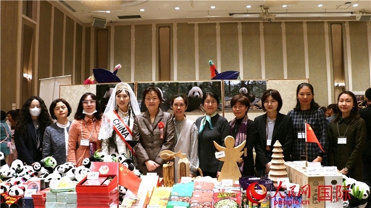 中國駐日本大使吳江浩夫人丁玥（左五）與使館人員在展位前合影留念。人民網(wǎng) 許可攝