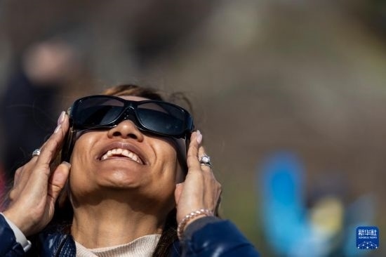 4月8日，一名女子在美國(guó)紐約州普拉茨堡觀看日食。新華社發(fā)（文森特·約翰遜攝）