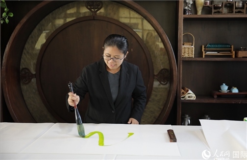 緬甸駐華大使館副館長、公使銜參贊杜欣瑪泰參加《五百筆·瀾湄合作》集體藝術(shù)創(chuàng)作。人民網(wǎng)王婧攝